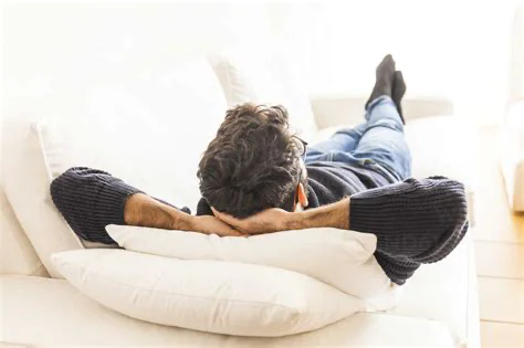 Person enjoying leisure time on clean white couch